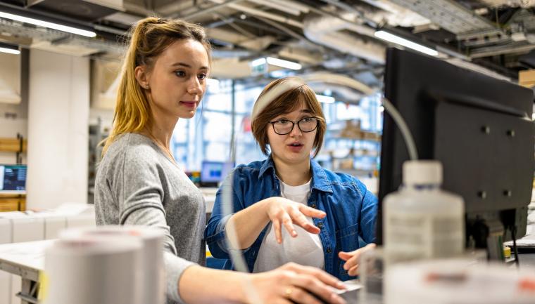 Two employees looking at a computer